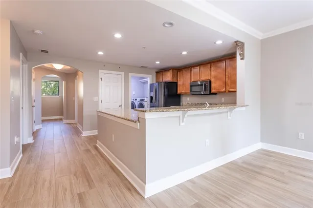 a kitchen with granite countertop cabinets stainless steel appliances a sink and wooden floor