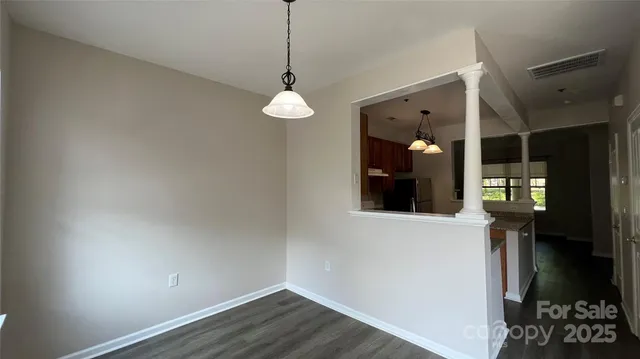 a view of a hallway with wooden floor and a chandelier