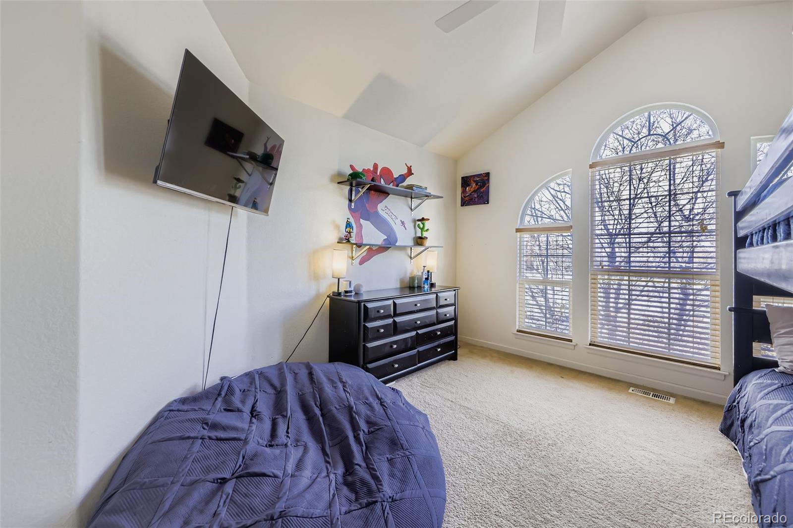 11668 Xavier Way Westminster, CO 80031 - Photo 16 of 22 a bedroom with a bed and a flat tv screen on the dresser