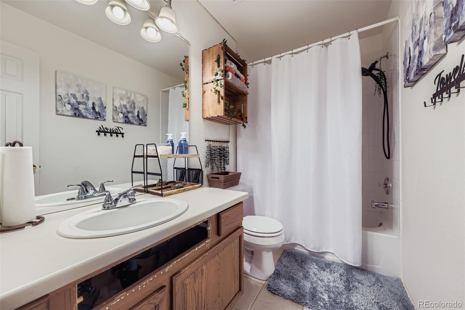 11668 Xavier Way Westminster, CO 80031 - Photo 17 of 22 a bathroom with a granite countertop sink toilet and shower