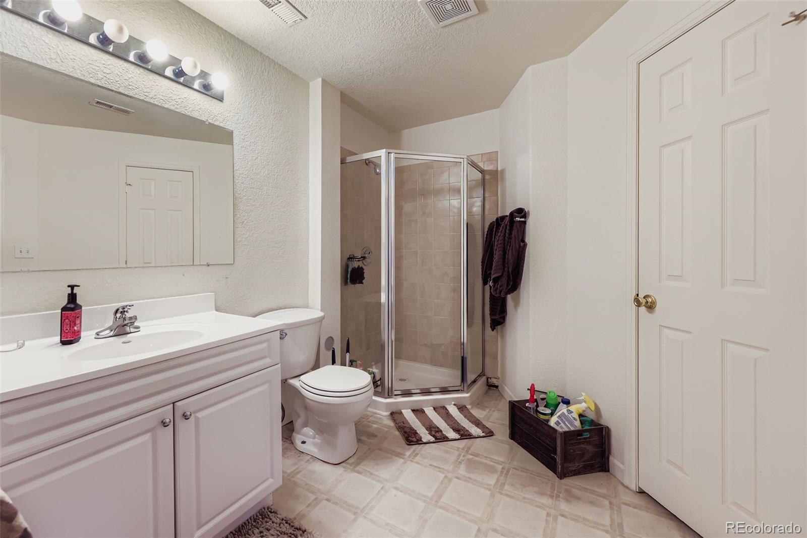 11668 Xavier Way Westminster, CO 80031 - Photo 18 of 22 a bathroom with a sink toilet and shower