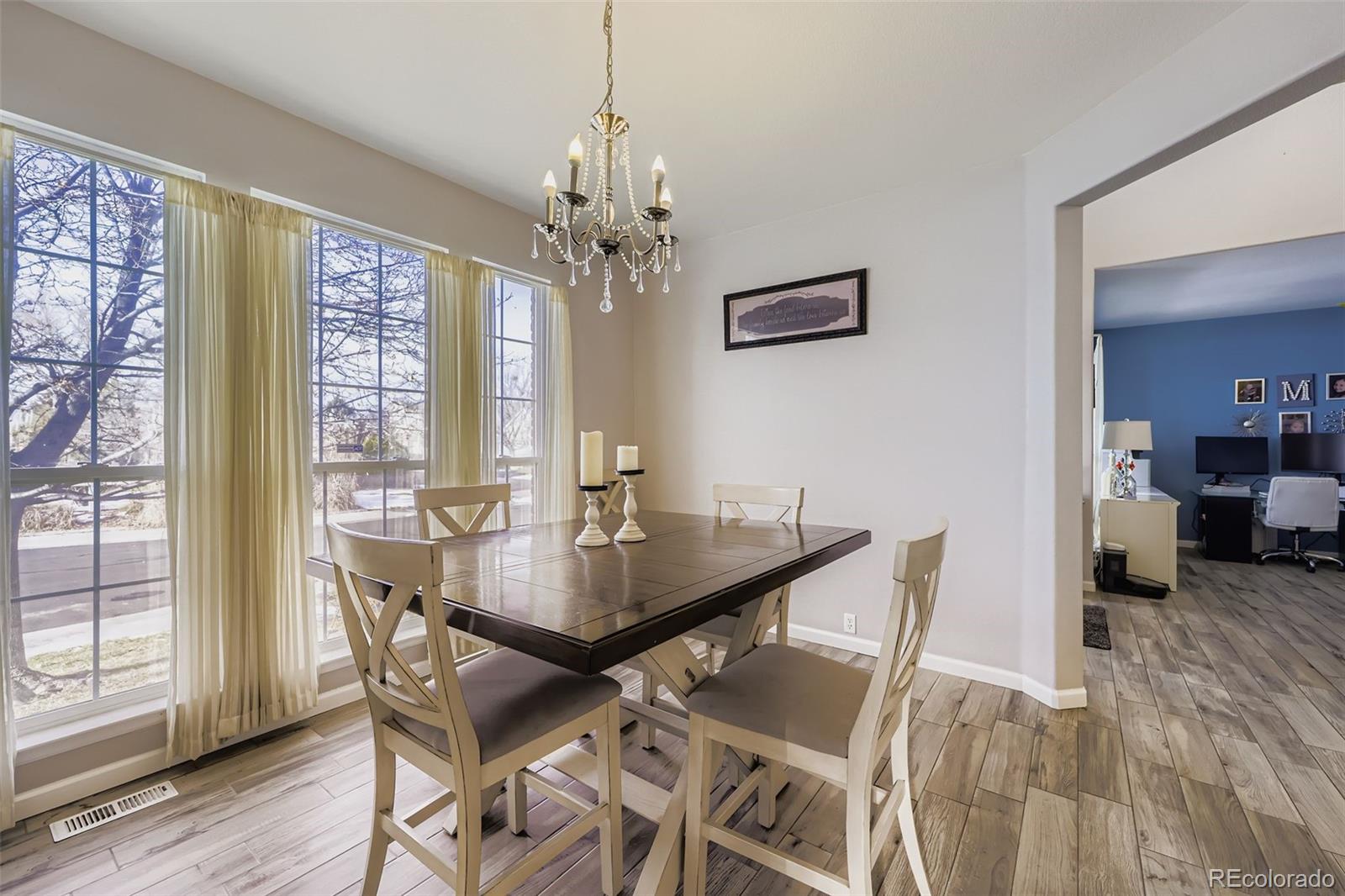 11668 Xavier Way Westminster, CO 80031 - Photo 3 of 22 a view of a dining room with furniture window and wooden floor