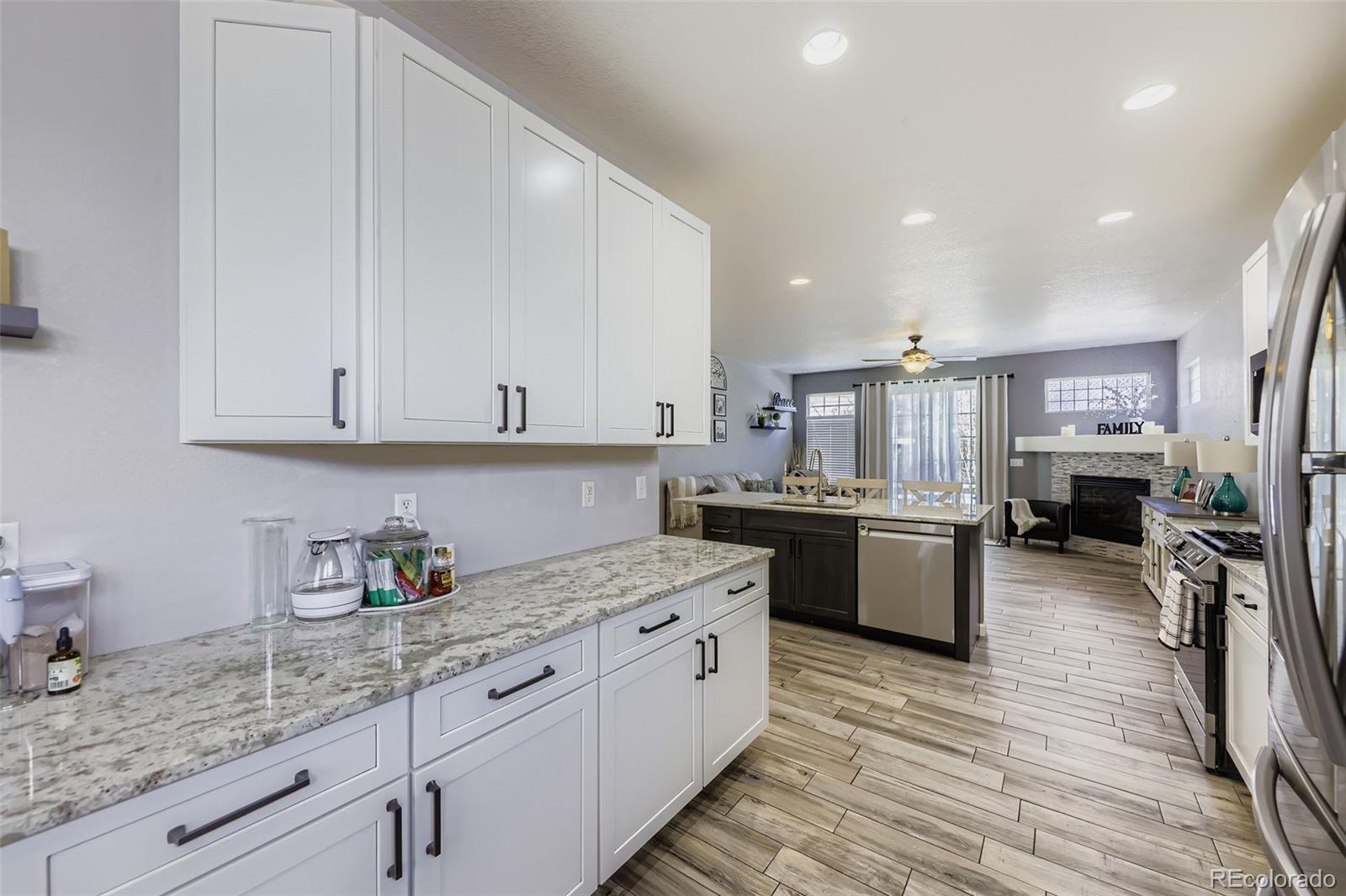 11668 Xavier Way Westminster, CO 80031 - Photo 5 of 22 a kitchen with stainless steel appliances granite countertop a sink dishwasher stove and white cabinets