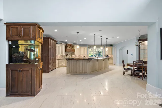 a kitchen with stainless steel appliances granite countertop a stove top oven a sink dishwasher and a refrigerator with wooden floor