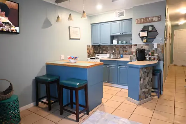 a room with kitchen island stainless steel appliances a sink and a refrigerator
