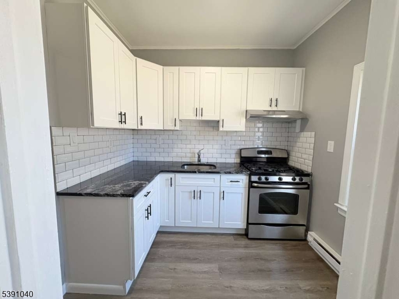 37 Mercer Street, Unit 1 Wallington, NJ 07057 - Photo 11 of 12 a kitchen with stainless steel appliances granite countertop a stove and a sink