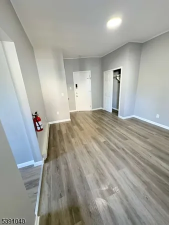 an empty room with wooden floor and stairs