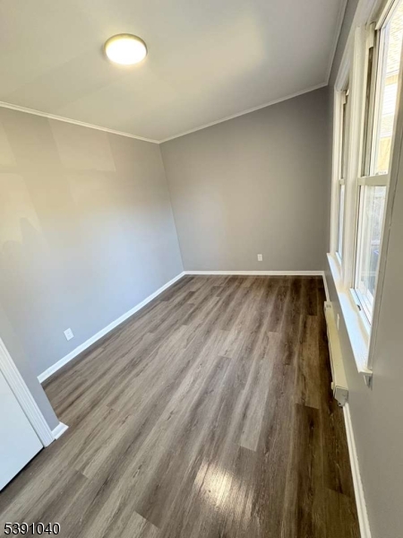 37 Mercer Street, Unit 1 Wallington, NJ 07057 - Photo 5 of 12 an empty room with wooden floor and windows