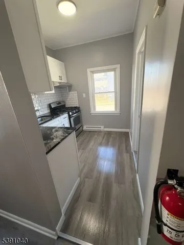 a kitchen with granite countertop white cabinets and white appliances