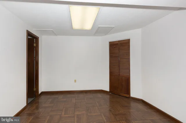 an empty room with wooden floor and staircase
