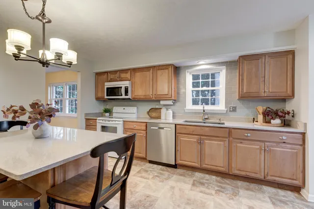 a kitchen with cabinets a center island stainless steel appliances cabinets and a counter top space