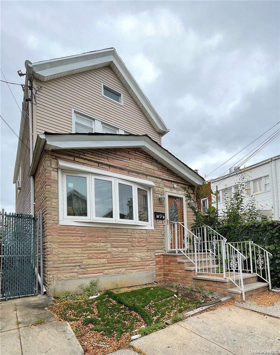 86-10 77th Street Queens, NY 11421 - Photo 1 of 1 a front view of a house with a garden