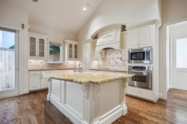 a large kitchen with stainless steel appliances granite countertop a stove and a sink