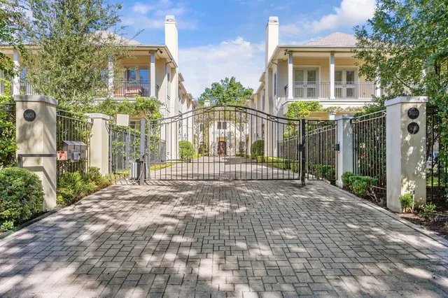 a view of a brick house with many windows next to a yard