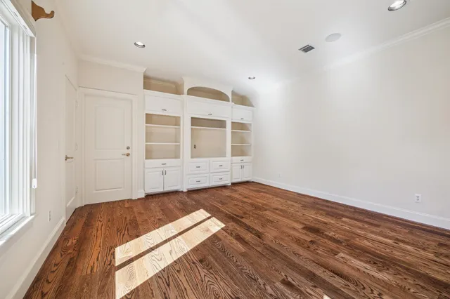 a view of empty room with wooden floor and windows