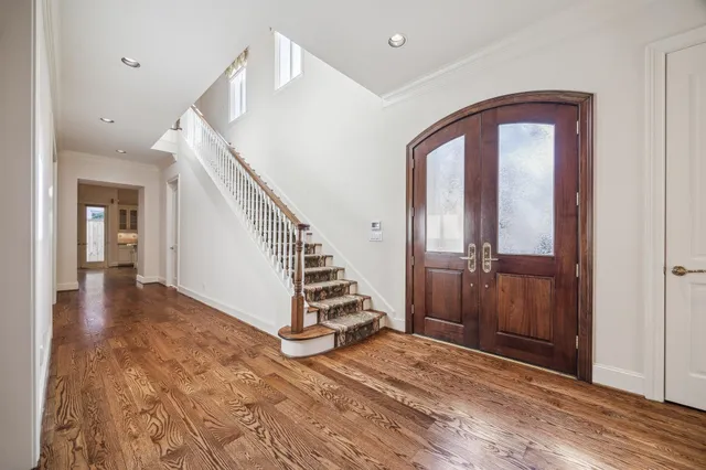 a view of a hallway with wooden floor and staircase