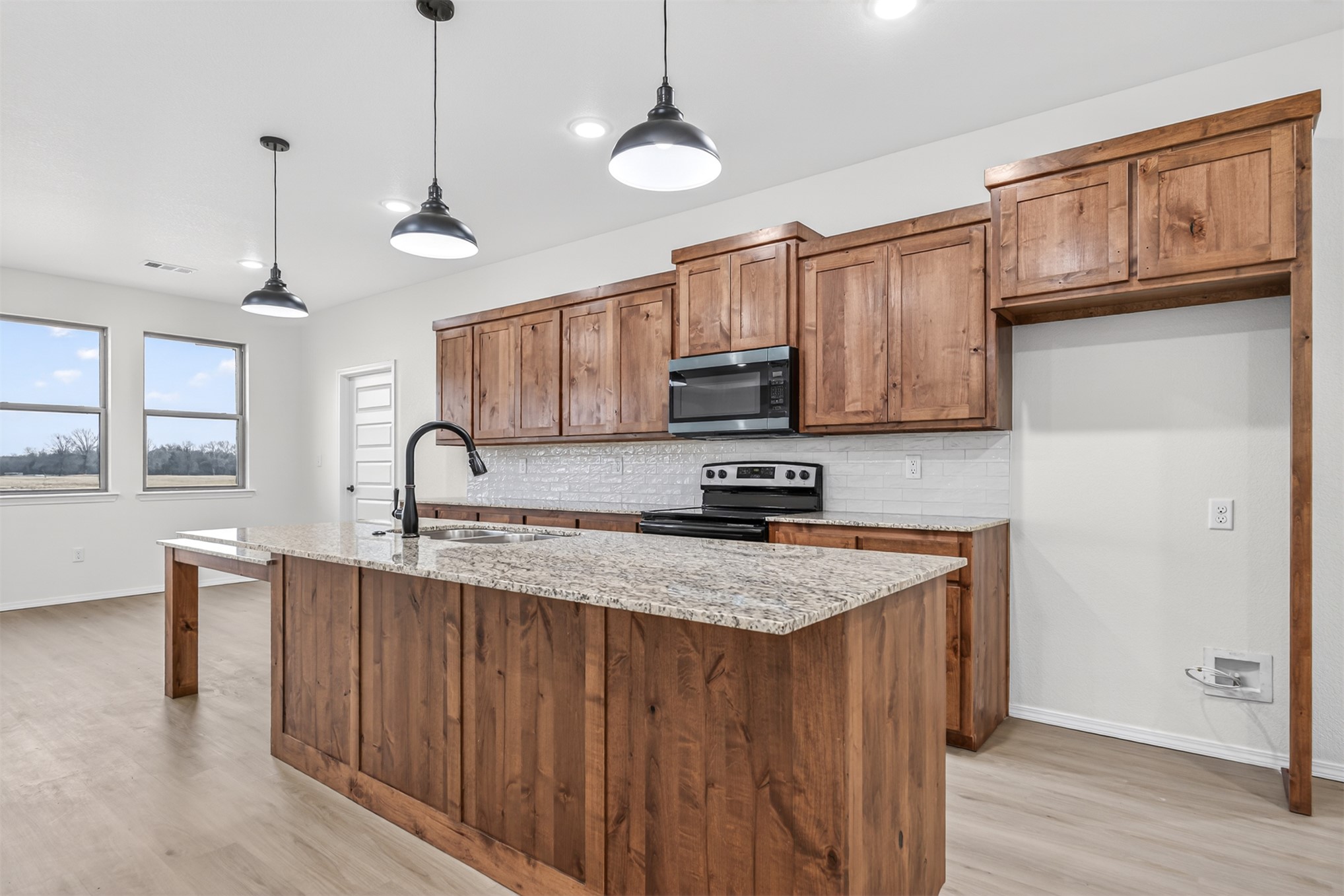 124 Countryside Way Pocola, OK 74902 - Photo 9 of 39 Kitchen featuring wood cabinetry, light-toned wood-finish flooring, granite countertops, and a subway tile backsplash