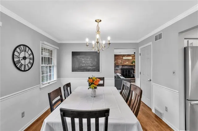 a view of a dining room with furniture a chandelier and wooden floor