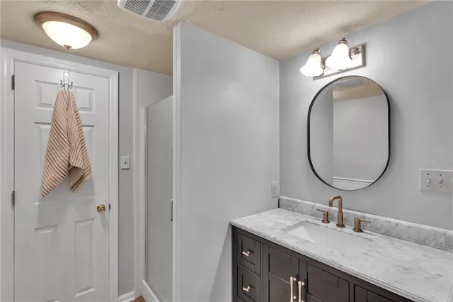 a bathroom with a granite countertop sink and a mirror