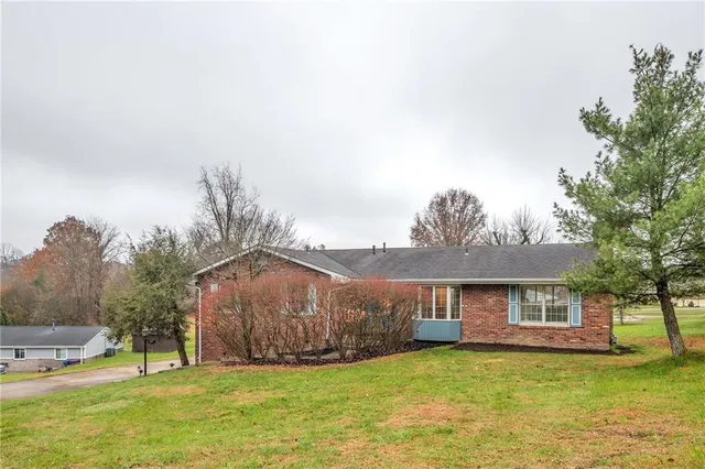 a white house with a big yard and large trees