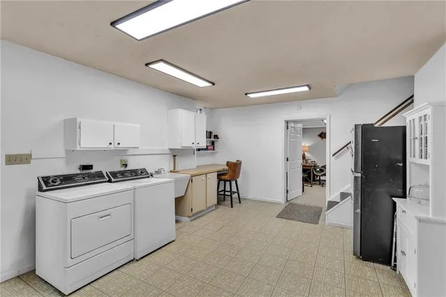 a kitchen with a refrigerator a stove top oven a sink a dining table and chairs