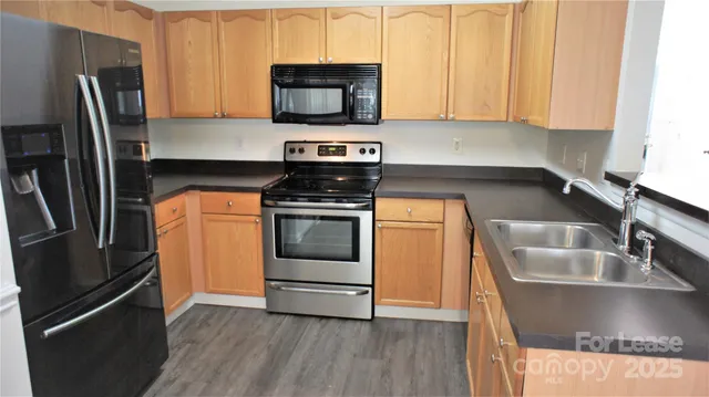 a kitchen with stainless steel appliances a stove microwave and sink