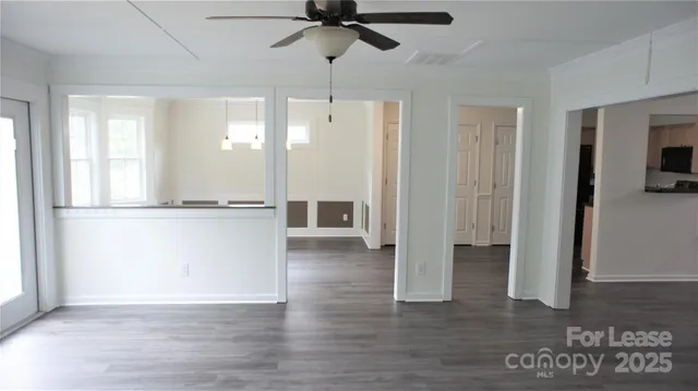 a view of a room with wooden floor and a ceiling fan