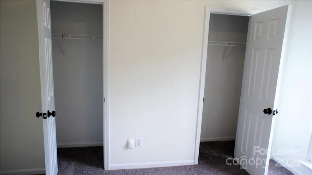 a view of a hallway with closet and wooden floor