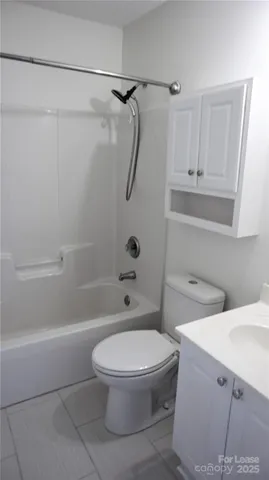 a white toilet and tub sitting next to a bathroom sink