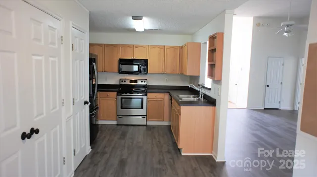 a kitchen with stainless steel appliances a refrigerator a stove top oven a sink and dishwasher