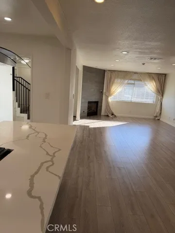a view of a living room a wooden floor and a fireplace