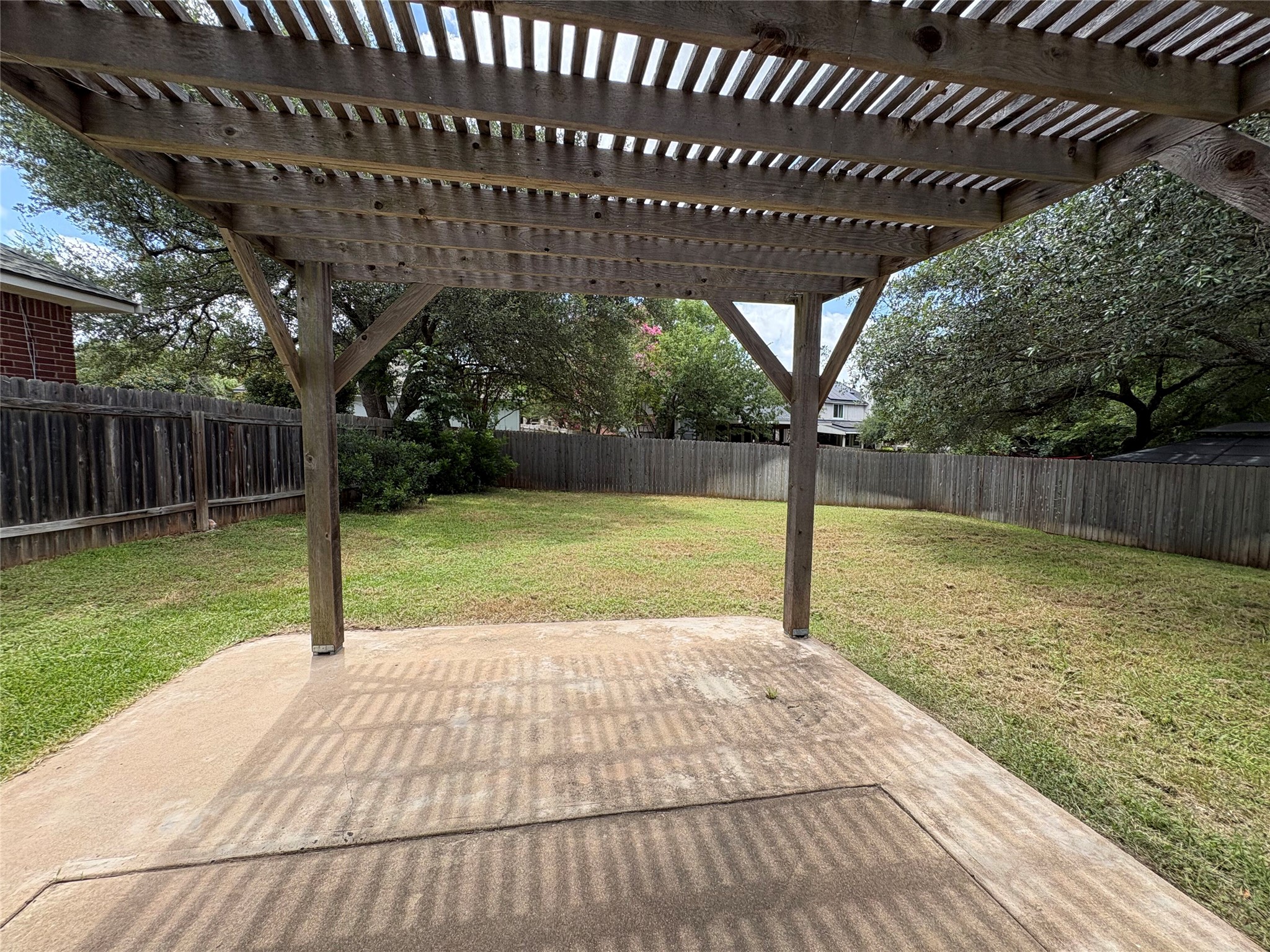 8103 Ephraim Road Austin, TX 78717 - Photo 34 of 35 A spacious yard with mature trees offers a private retreat beneath a charming wooden pergola.