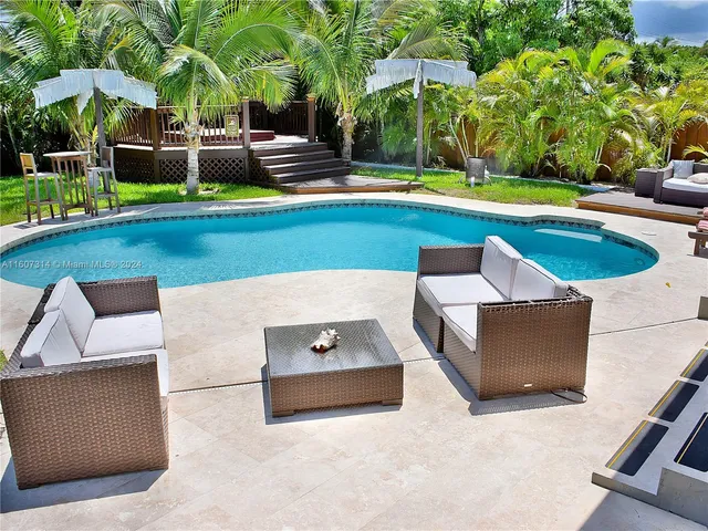 an aerial view of a house with swimming pool patio and outdoor seating