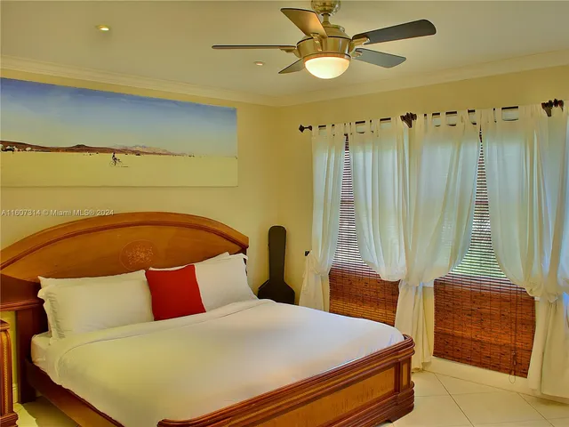 a view of a white house with a yard and potted plants