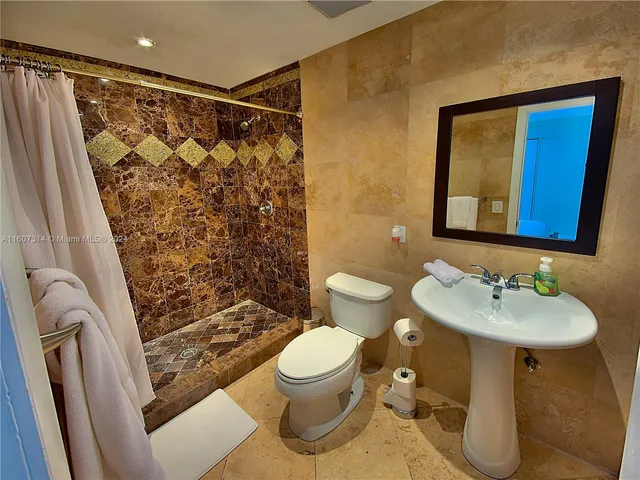a bathroom with a sink toilet and shower