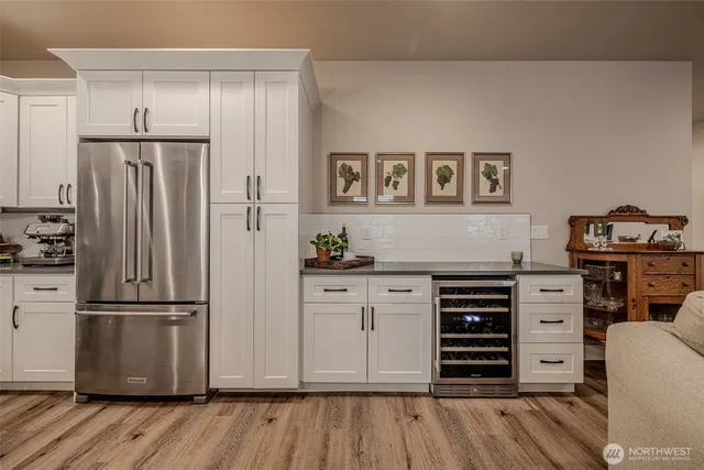 a kitchen with stainless steel appliances a refrigerator and wooden floor