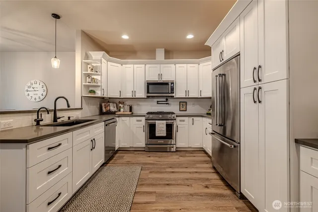 a kitchen with white cabinets and appliances