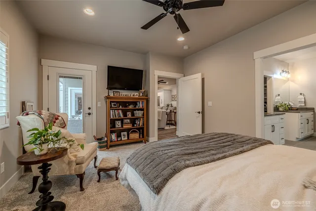 a bedroom with a bed a television and a book shelf