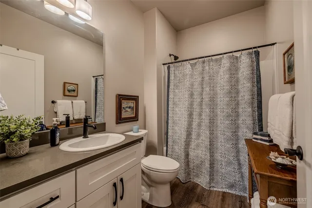 a bathroom with a granite countertop sink toilet and shower