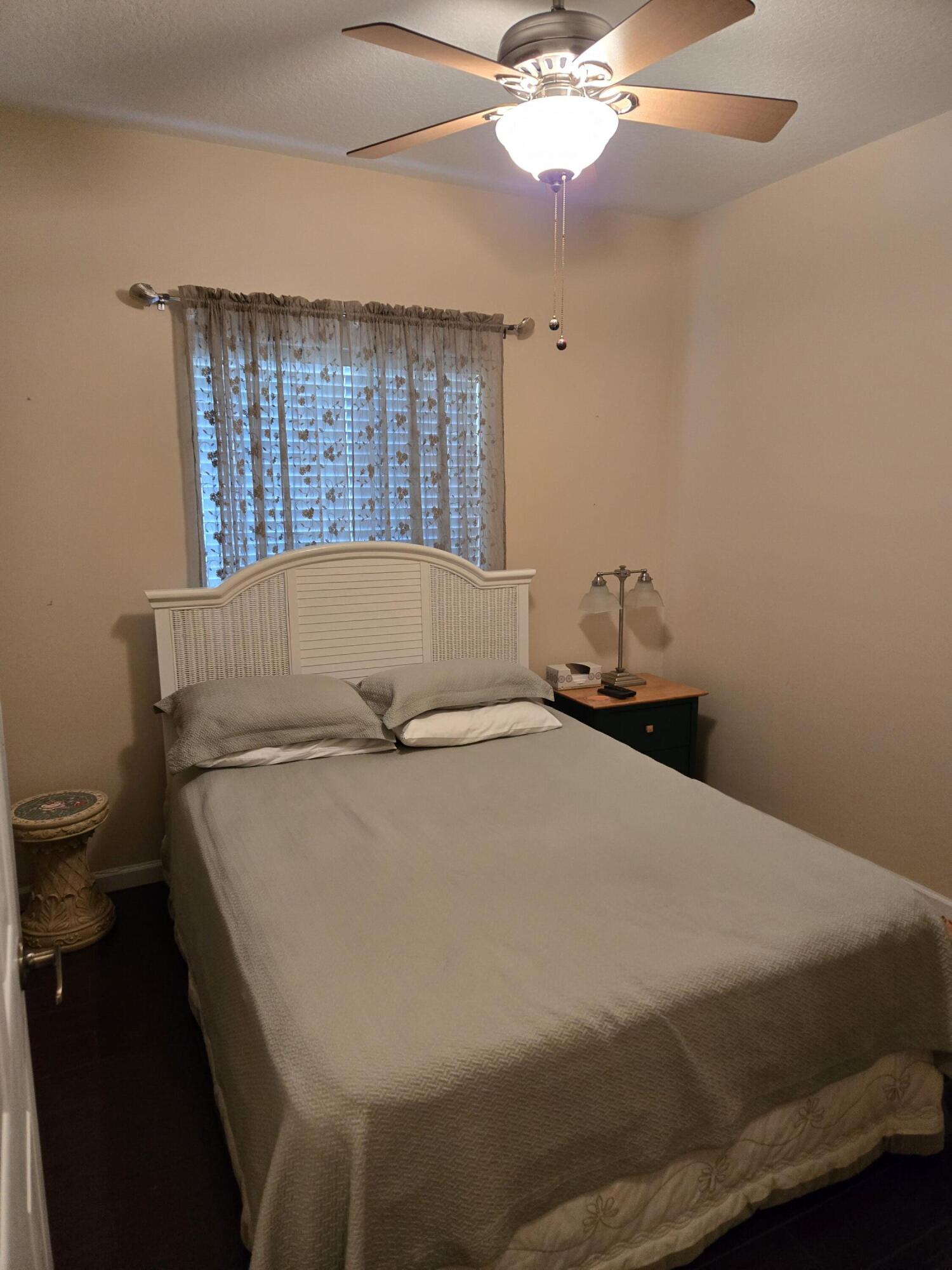 2297 Windjammer Way West Palm Beach, FL 33411 - Photo 11 of 56 a bedroom with a bed and a chandelier