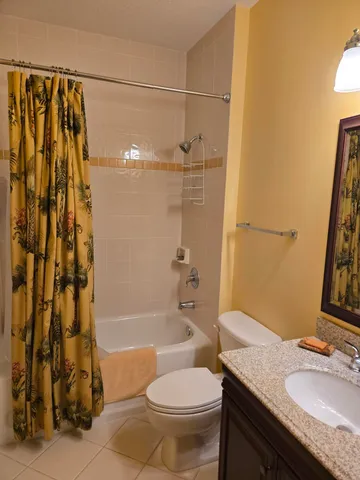 a bathroom with a granite countertop toilet sink and a mirror