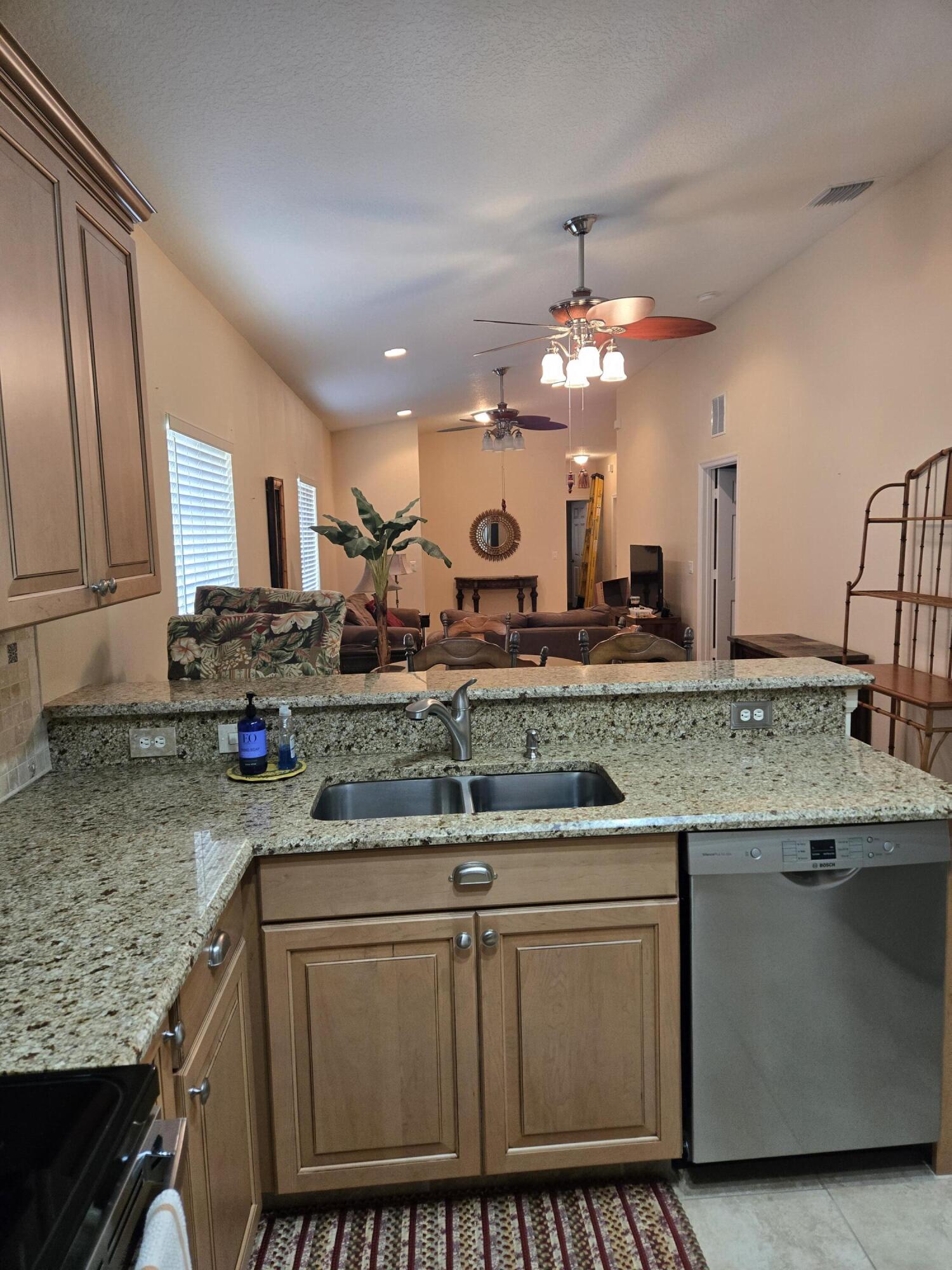 2297 Windjammer Way West Palm Beach, FL 33411 - Photo 21 of 56 a kitchen with stainless steel appliances granite countertop a sink and cabinets