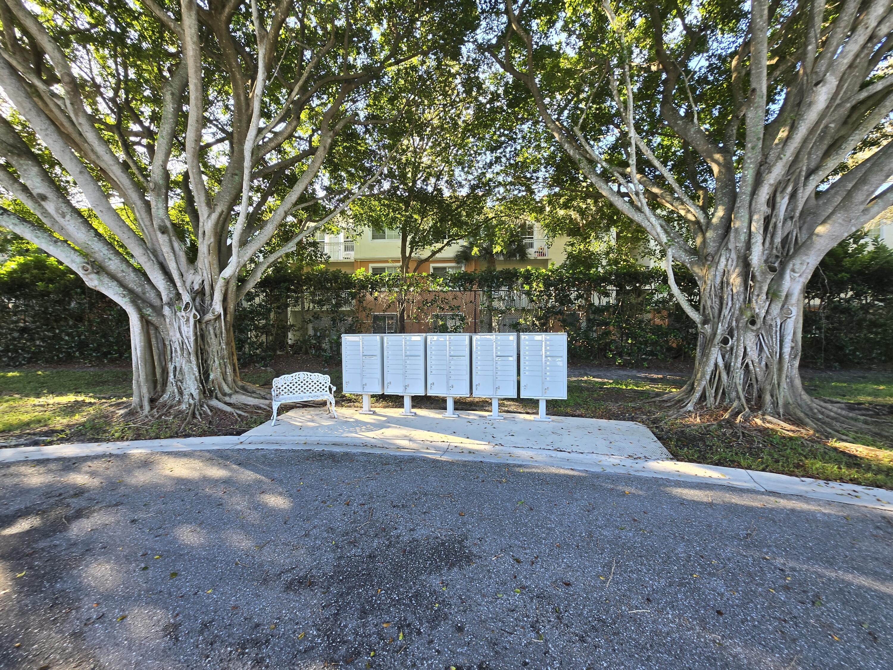 2297 Windjammer Way West Palm Beach, FL 33411 - Photo 34 of 56 a backyard of a house with table and chairs under a large tree