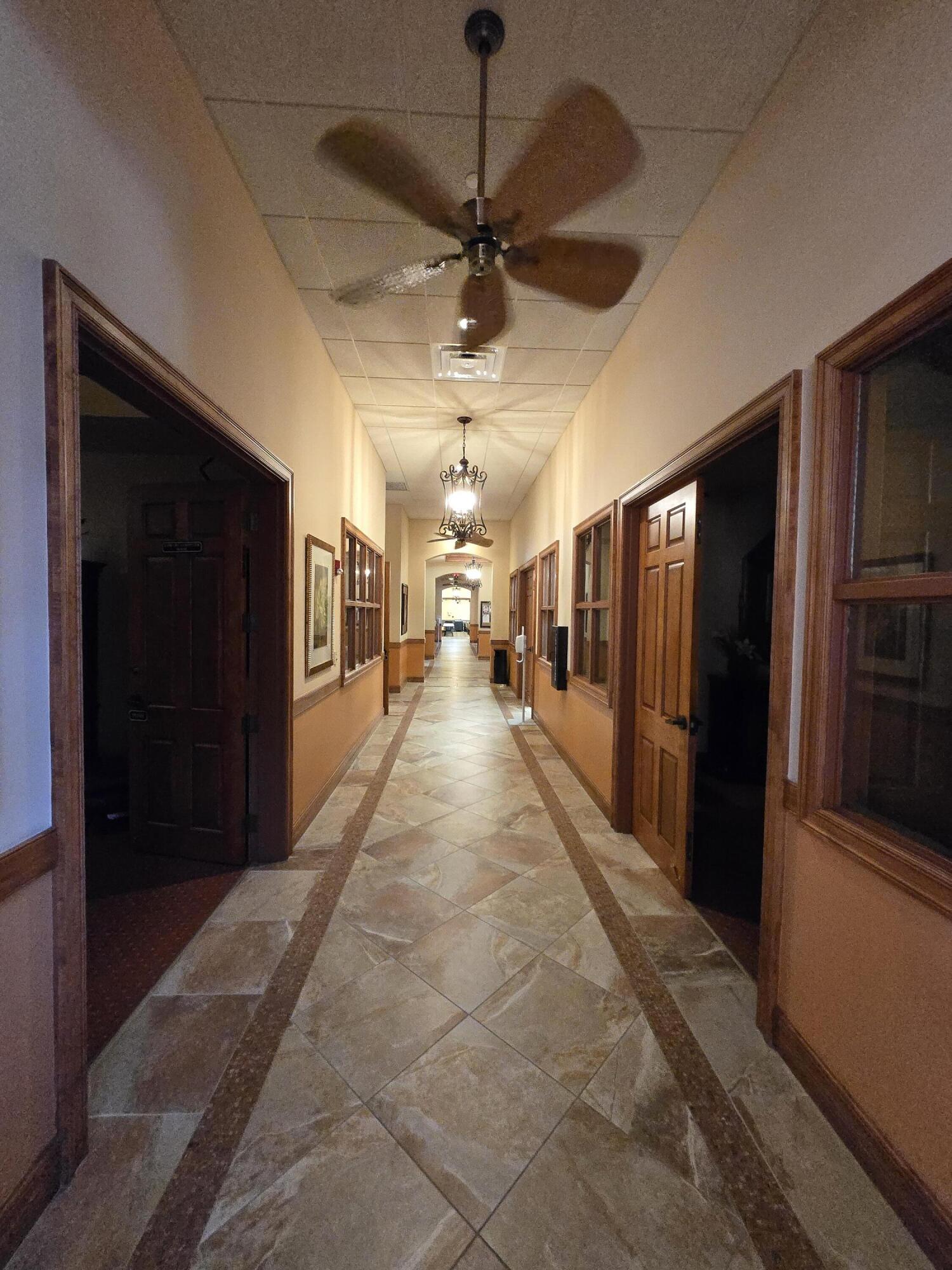 2297 Windjammer Way West Palm Beach, FL 33411 - Photo 42 of 56 a hallway with sliding door and chandelier
