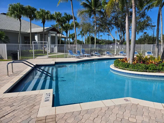a view of a swimming pool with a table and chairs under an umbrella