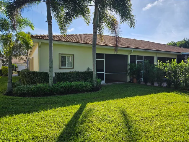 a front view of a house with a yard and potted plants
