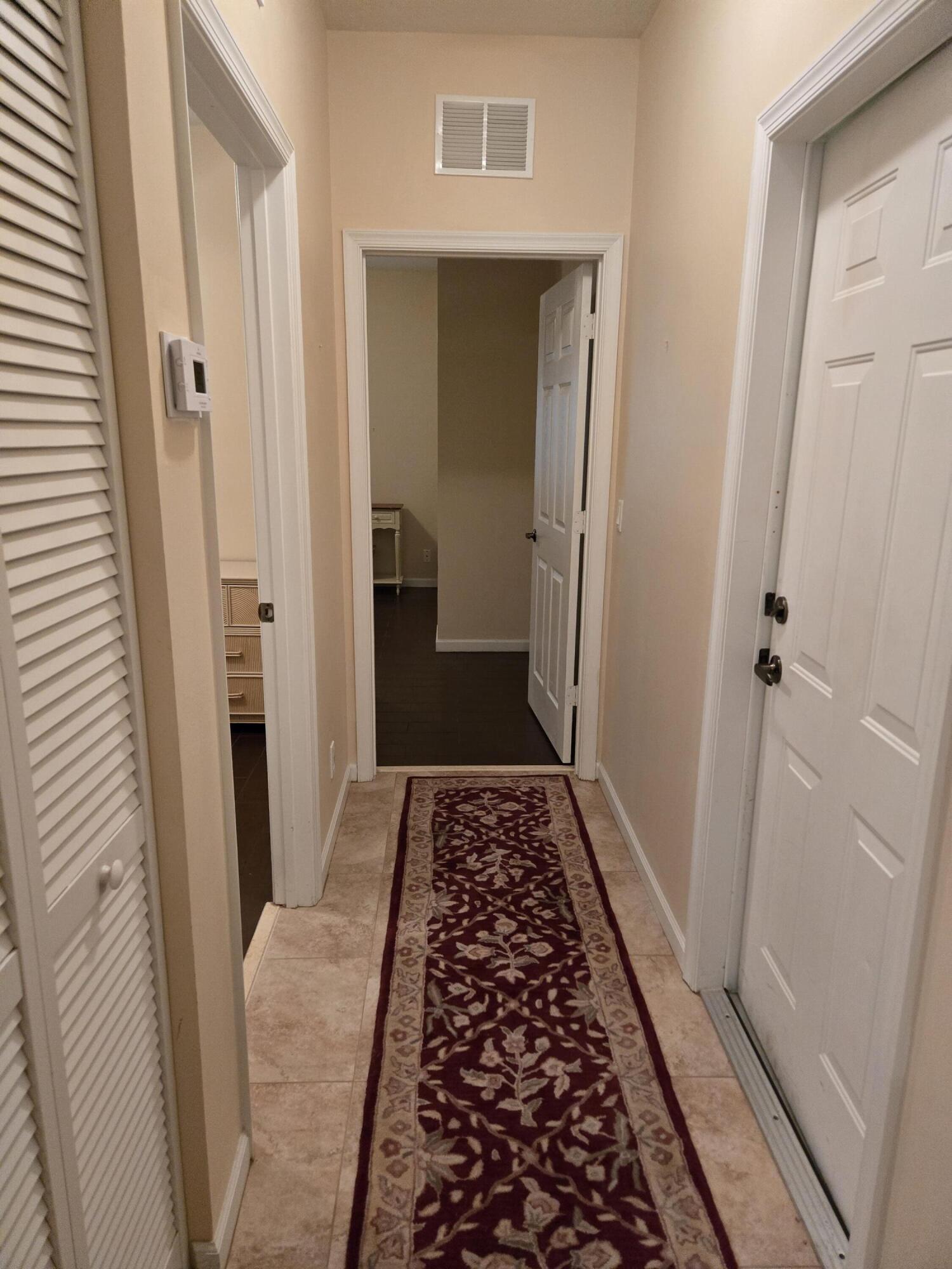 2297 Windjammer Way West Palm Beach, FL 33411 - Photo 10 of 56 a view of hallway with wooden floor and a rug