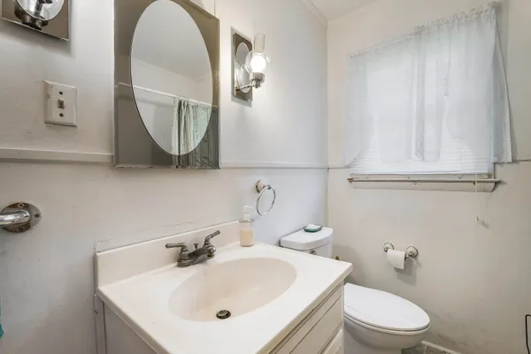 a bathroom with a toilet a sink and mirror