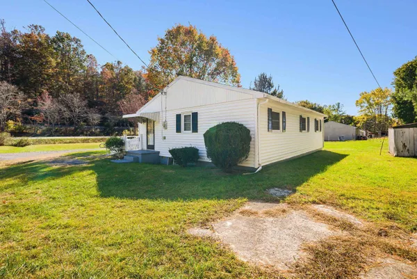 a view of a white house with a backyard