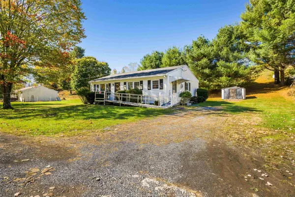 a front view of a house with a yard and large trees